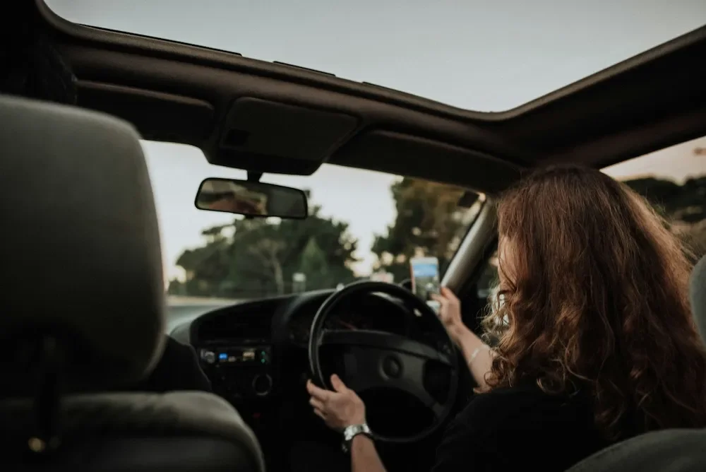 Woman driving alone with both hands on the steering wheel